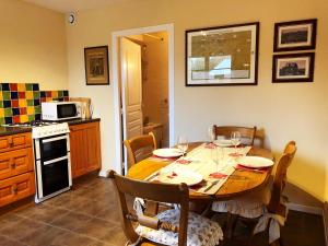 a kitchen with a wooden table with chairs and a table and a stove at Coury House, Chavasse Farm, Somme in Hardecourt-aux-Bois +16 photos