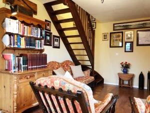 a living room with a couch and a book shelf with books at Coury House, Chavasse Farm, Somme in Hardecourt-aux-Bois
