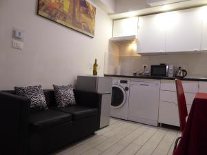 uma sala de estar com um sofá e uma máquina de lavar roupa em Mascarella House Bologna - self check-in em Bolonha