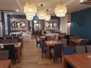 a restaurant with wooden tables and blue walls and chandeliers at OW Sorrento in Bystrzyca Kłodzka