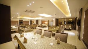Un restaurante con mesas y sillas en una habitación. en Dhamma Grand Hotel Resort, en Bodh Gaya