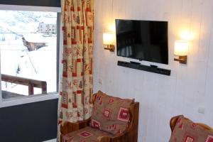 Cette chambre dispose d'une télévision, d'une chaise et d'une fenêtre. dans l'établissement Epicea Avoriaz, three bedroom apartment, 4th floor, 8 to 10 ppl, à Avoriaz