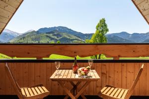 a table with two chairs and a bowl of fruit and wine glasses at Domek w Roztokach z widokiem na Tatry in Kościelisko