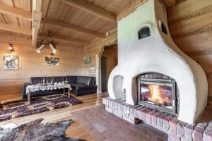 a living room with a fireplace in a log cabin at Domek w Roztokach z widokiem na Tatry in Kościelisko