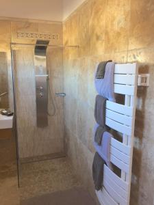 a bathroom with a shower and a stack of towels at L'ESCALE COTE BLEUE B&B AND Spa in Sausset-les-Pins
