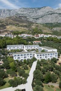 an aerial view of a building with mountains in the background at Bluesun hotel Neptun - All inclusive in Tučepi