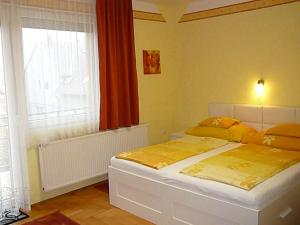 a bedroom with a bed and a large window at Hévíz Erika Apartman in Hévíz