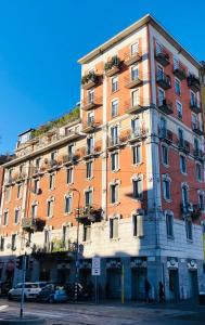 un alto edificio arancione su una strada di città di Rodica Comfort Home Milano Navigli a Milano