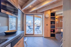 a kitchen with a large window and a living room at Chalet Béla Vya in Arc 1600