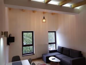 a living room with a couch and two windows at Marušić Apartments in Vlasic
