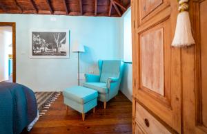 a bedroom with two blue chairs and a chair and a table at Casa Azul in Fuencaliente de la Palma