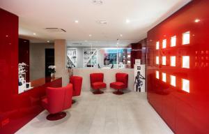 a red salon with red chairs and a waiting room at Le Grand Hôtel Le Touquet-Paris-Plage in Le Touquet-Paris-Plage