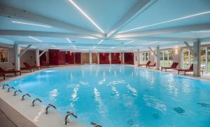 a large swimming pool in a hotel room at Le Grand Hôtel Le Touquet-Paris-Plage in Le Touquet-Paris-Plage