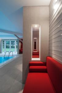 a lobby with a red couch and a swimming pool at Le Grand Hôtel Le Touquet-Paris-Plage in Le Touquet-Paris-Plage