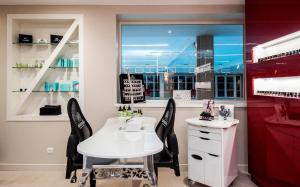 a salon with a white table and two black chairs at Le Grand Hôtel Le Touquet-Paris-Plage in Le Touquet-Paris-Plage