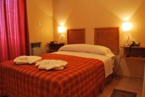 a bedroom with a bed with two towels on it at Hotel El Torreon in Mendoza