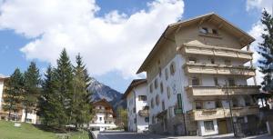 a large white building with a pointed roof at Albergo Genziana in San Vigilio Di Marebbe