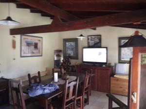 comedor con mesa y TV en "Mahilo Casa" en Villa Gesell