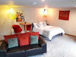 a bedroom with a bed and a couch and a table at The Village Studio Apartments in Moate