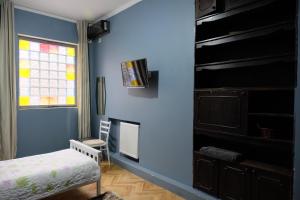 a blue room with a bed and a window at Mia B&B Old Tbilisi in Tbilisi City