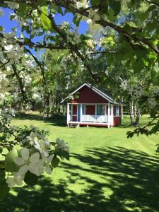 une maison rouge et blanche au milieu d'une cour dans l'établissement Djurviks Gästgård, à Gottby