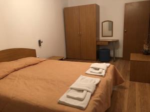 a bedroom with a bed with towels on it at Apartment Svetla in Laplandia Complex in Pamporovo