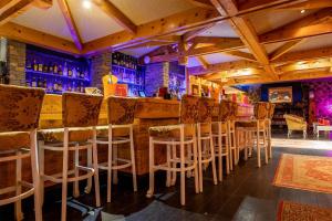 un bar con una fila de taburetes en un restaurante en Madame Vacances Hôtel Ibiza en Les Deux Alpes