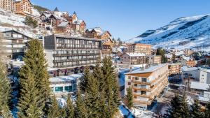 a resort town in the mountains with snow at Madame Vacances Hôtel Ibiza in Les Deux Alpes