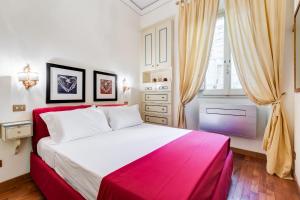 - une chambre avec un lit rouge et blanc et une fenêtre dans l'établissement Elegant Apartment Rome, à Rome