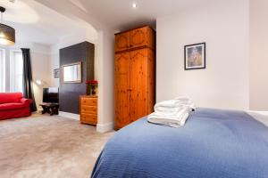 a bedroom with a blue bed and a red couch at Gorgeous Town Centre Apt with Courtyard Garden in Bournemouth