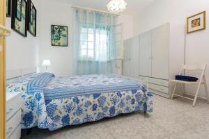 マリーナ・ディ・マンカヴェルサにあるCasa Vacanze LE CONCHIGLIEのベッドルーム(青と白のベッド1台、窓付)