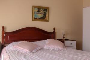 a bed in a bedroom with a picture on the wall at Telhadense in Castelo Branco