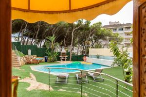 a pool with a table and chairs in a yard at Eco Geo Sol in Lloret de Mar