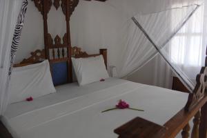 a bedroom with a bed with flowers on it at Panga Chumvi Beach Resort in Matemwe
