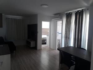 sala de estar con mesa y TV en Real Plaza Flat 1505, en Curitiba