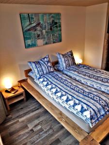 a bed with blue and white sheets and pillows at Churchstreet appartements in Meiringen