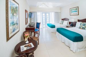 a hotel room with two beds and a table at Bay Gardens Marina Haven in Gros Islet