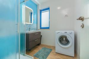a bathroom with a washing machine and a sink at Dajla 66 in Dajla