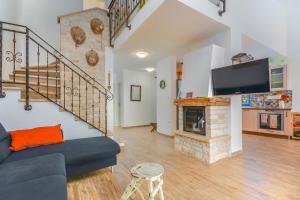 ein Wohnzimmer mit einer blauen Couch und einem Kamin in der Unterkunft Dajla 66 in Dajla