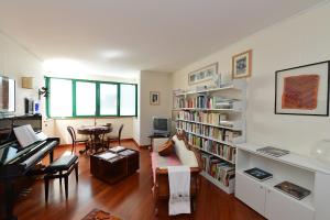 uma sala de estar com um piano e uma sala de estar com uma estante de livros em B&b Giudecca Bella em Veneza