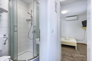 a bathroom with a shower with a glass door at Apartmani ATL in Rogoznica +47 photos