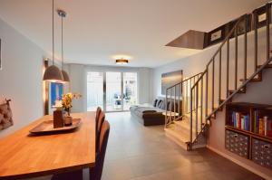 a living room with a dining room table and a staircase at Urbaner Lifestyle im klimaneutralen Effizienzhaus in Hamburg