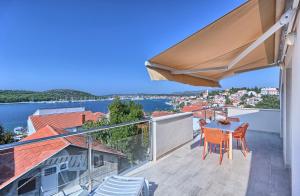 a balcony with a table and chairs and a view of the water at Apartmani ATL in Rogoznica