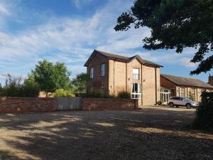 a brick house with a car parked in front of it at The Old Granary Country-retreat in Burton Agnes