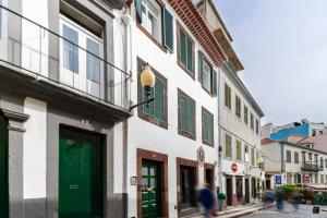 a building with a green door on a street at Funchal City Apartments in Funchal