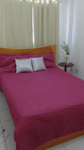 a large purple bed with two white pillows on it at Natal RN Apartamento in Parnamirim