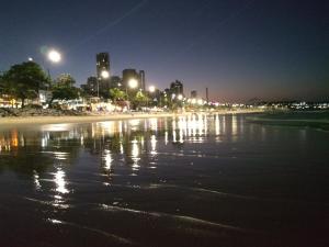una vista su una spiaggia notturna con luci di Natal RN Apartamento a Parnamirim