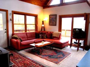 a living room with a red couch and a coffee table at The Catskill Cabin in Elka Park