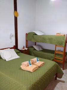 圣克莱门特雷图尤Hotel El Parque的客房设有两张带毛巾的绿色床。