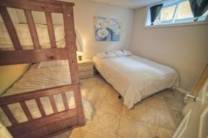 1 Schlafzimmer mit 2 Etagenbetten und einem Fenster in der Unterkunft Chalet Potvin Bouchard in LʼAnse-Saint-Jean